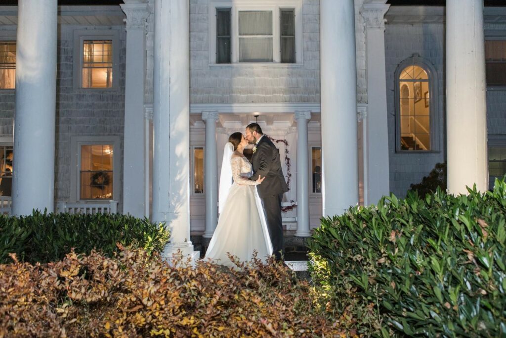 couple kissing outside mansion