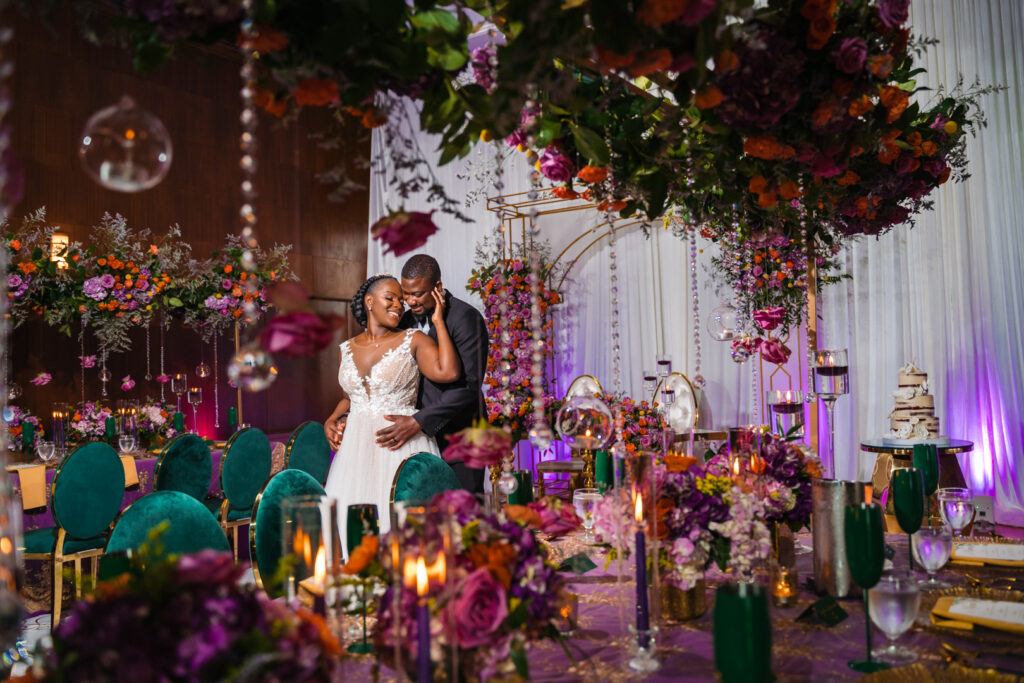 Bride and Groom holding each other in colorful reception room