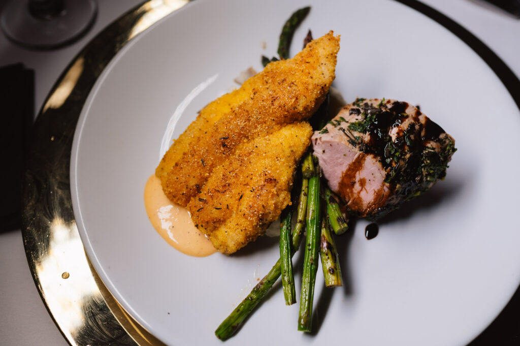 pork, fish and asparagus on white plate
