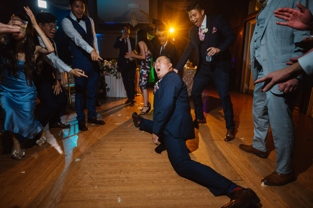 Man doing splits on wedding dance floor