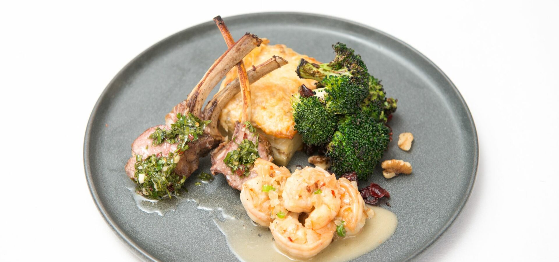 lamb chops, shrimp and broccoli on gray plate