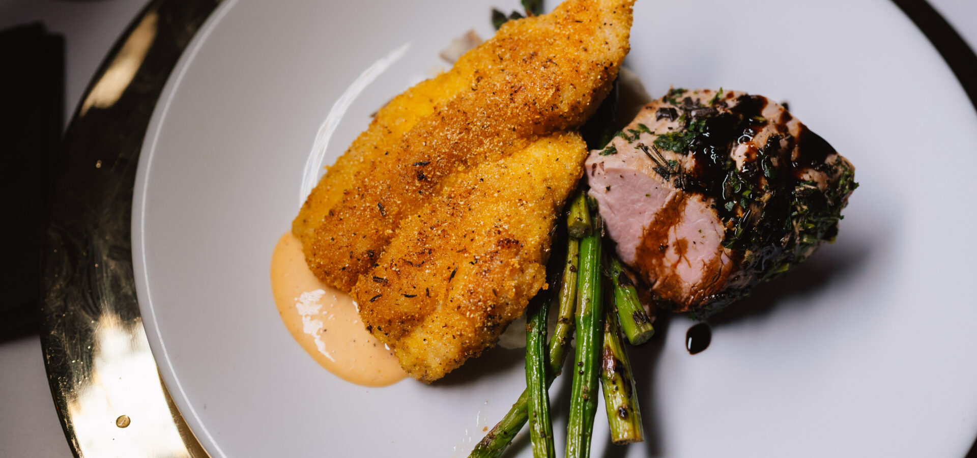 elegant pork, fish and asparagus on white plate