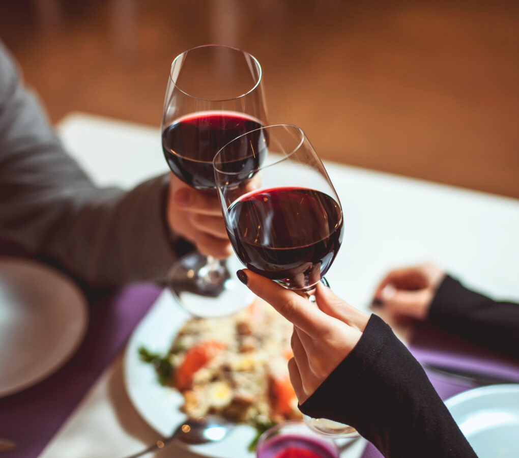 couple cheersing wine glasses