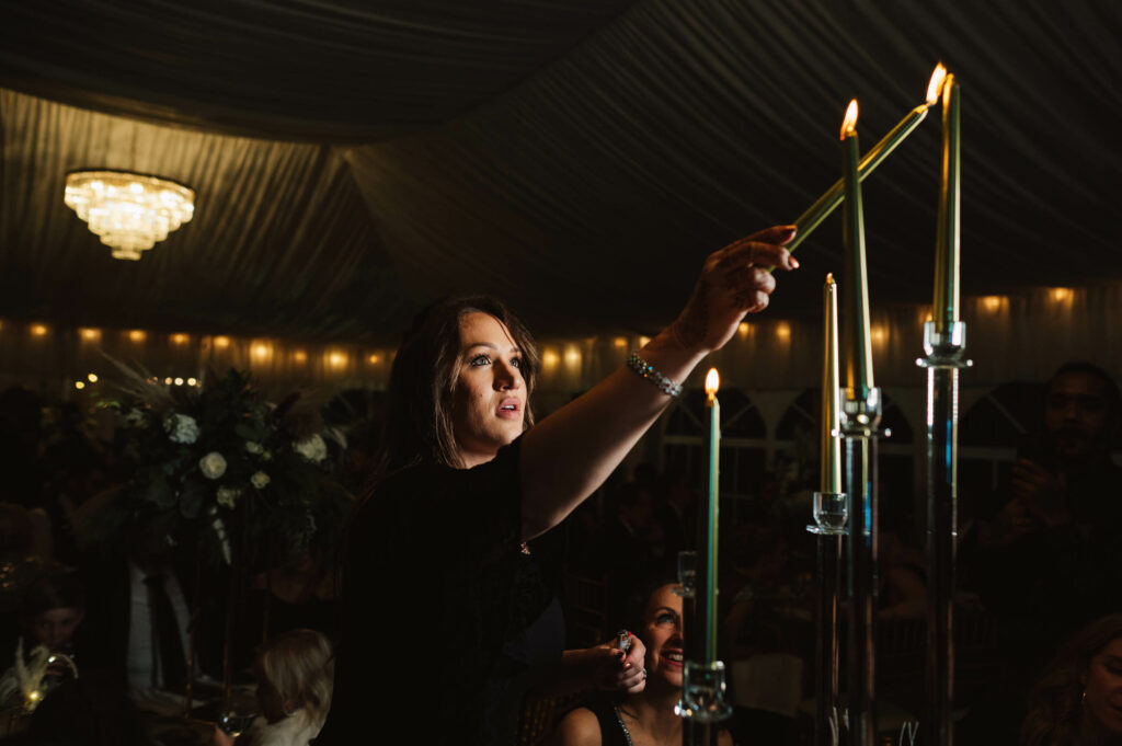 Woman lighting candles in an event tent at night