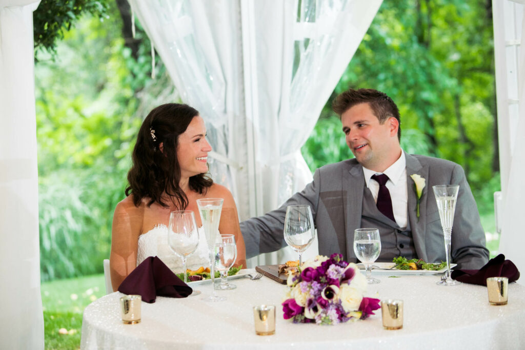bride and groom at head table in white tent