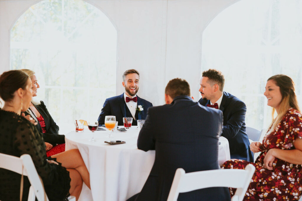 wedding party at a table in white tent